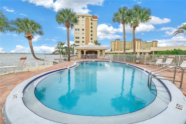 view of swimming pool with a water view and a patio