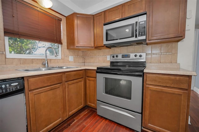 kitchen featuring appliances with stainless steel finishes, dark hardwood / wood-style floors, tasteful backsplash, and sink