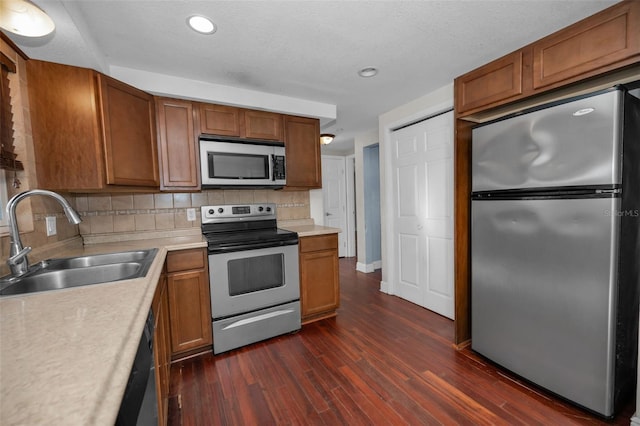 kitchen featuring backsplash, sink, stainless steel appliances, and dark hardwood / wood-style floors