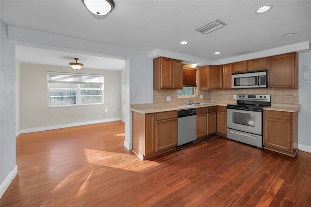 kitchen featuring dark hardwood / wood-style flooring, sink, appliances with stainless steel finishes, and tasteful backsplash