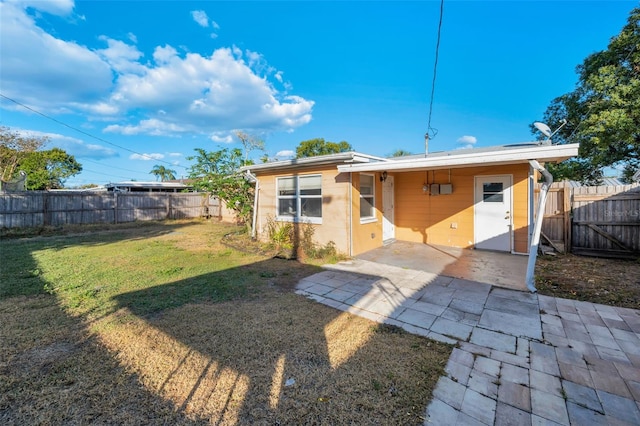 rear view of house with a lawn and a patio area