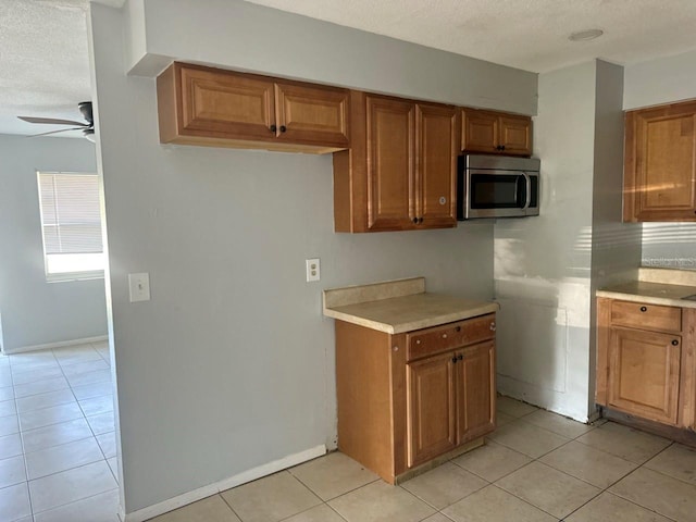 1386 19th St, Sarasota, FL 34234 - kitchen featuring stainless steel microwave, a ceiling fan, brown cabinetry, and light countertops