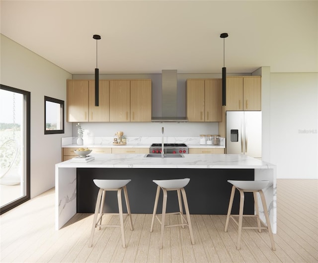 kitchen with light stone counters, white fridge with ice dispenser, decorative light fixtures, and wall chimney range hood