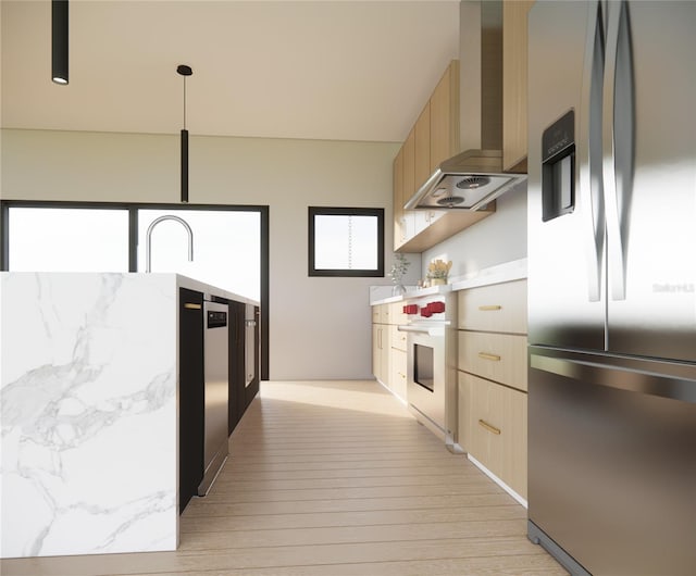 kitchen featuring light brown cabinets, wall chimney exhaust hood, stainless steel fridge, oven, and decorative light fixtures