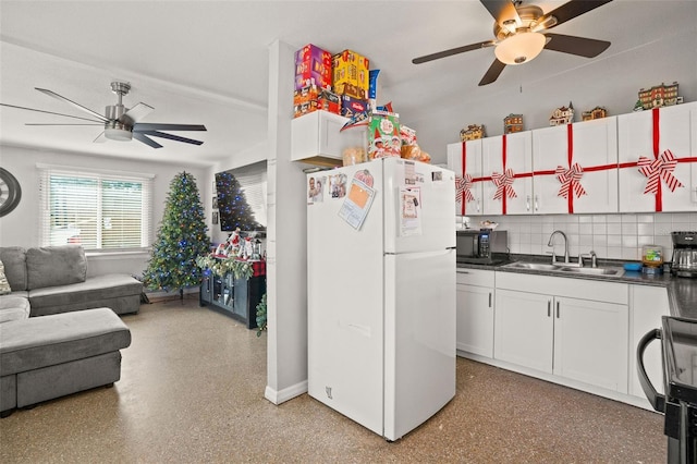 kitchen with white cabinets, white refrigerator, sink, stainless steel stove, and tasteful backsplash