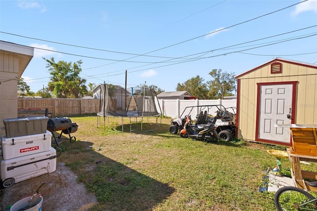 view of yard featuring a storage unit and a trampoline