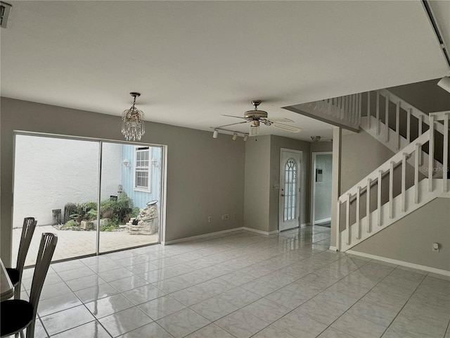 interior space with light tile patterned floors and ceiling fan with notable chandelier