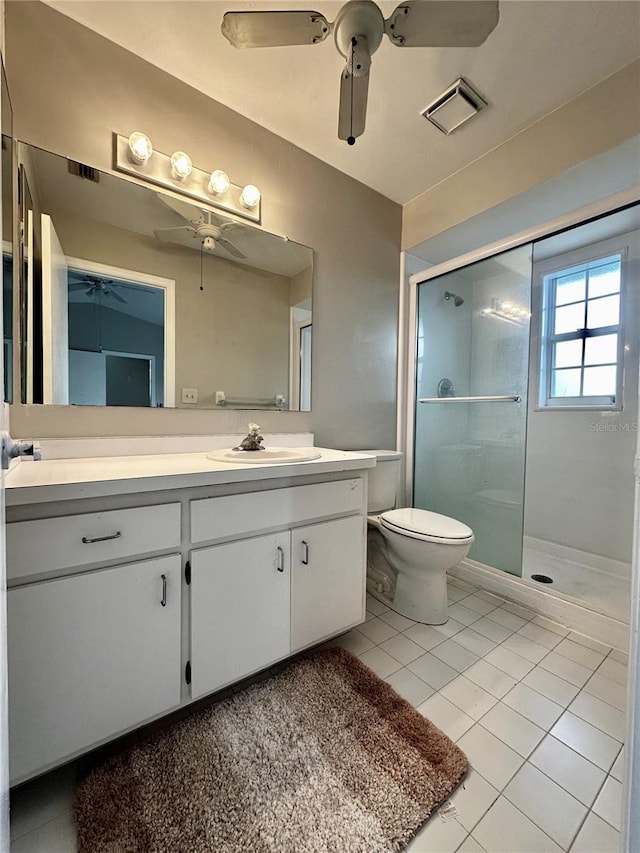 bathroom with toilet, vanity, tile patterned floors, and an enclosed shower