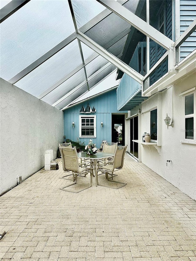 view of patio featuring glass enclosure