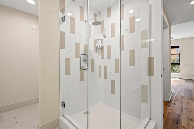 bathroom featuring hardwood / wood-style floors and a shower with shower door