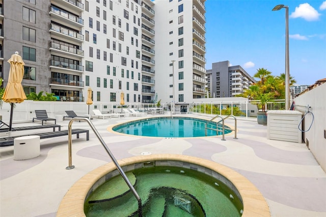 view of pool with a community hot tub and a patio