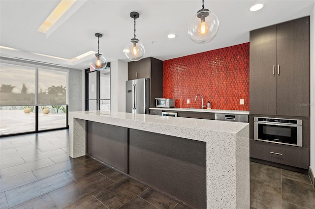 kitchen with tasteful backsplash, light stone countertops, pendant lighting, and appliances with stainless steel finishes