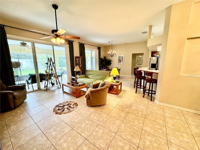 living room featuring light tile patterned floors, a healthy amount of sunlight, and ceiling fan with notable chandelier