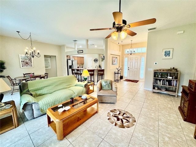 tiled living room with ceiling fan with notable chandelier