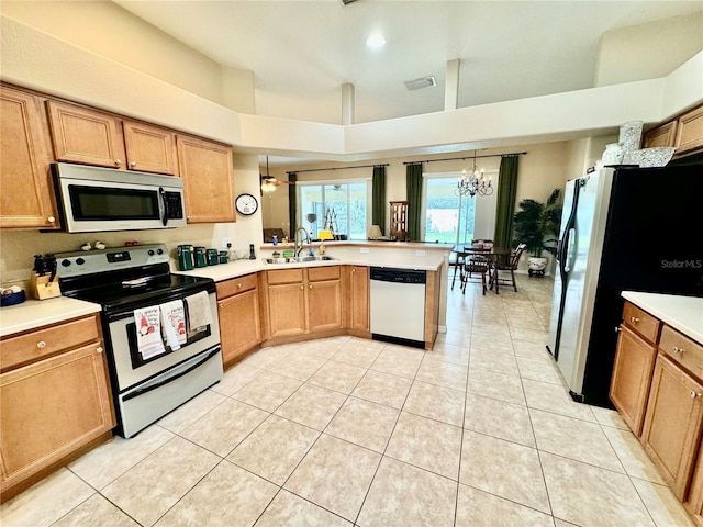 kitchen featuring a notable chandelier, hanging light fixtures, sink, and appliances with stainless steel finishes