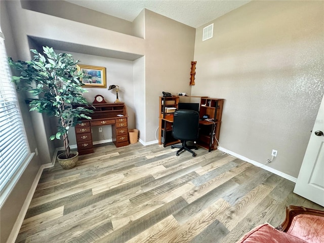 office space with a textured ceiling and light hardwood / wood-style floors