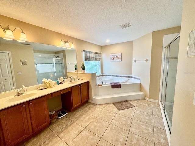 bathroom with tile patterned floors, vanity, shower with separate bathtub, and a textured ceiling