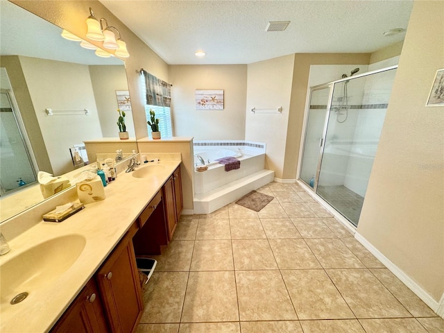 bathroom featuring plus walk in shower, a textured ceiling, vanity, and tile patterned floors