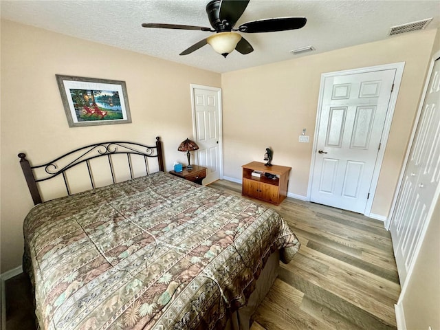 bedroom with ceiling fan, a closet, a textured ceiling, and light wood-type flooring