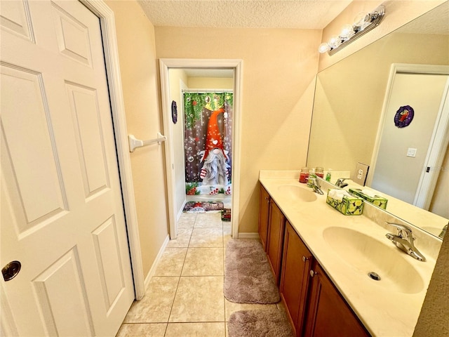 bathroom with tile patterned floors, vanity, and a textured ceiling