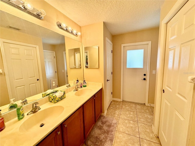 bathroom with vanity, a textured ceiling, and tile patterned floors