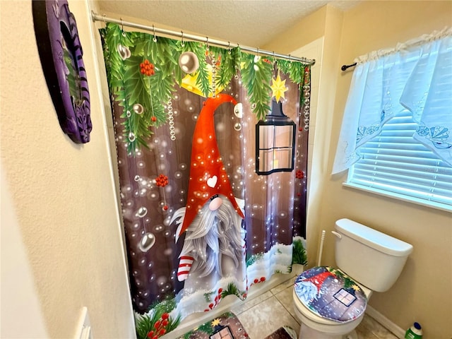 bathroom with tile patterned floors, toilet, a textured ceiling, and a shower with shower curtain