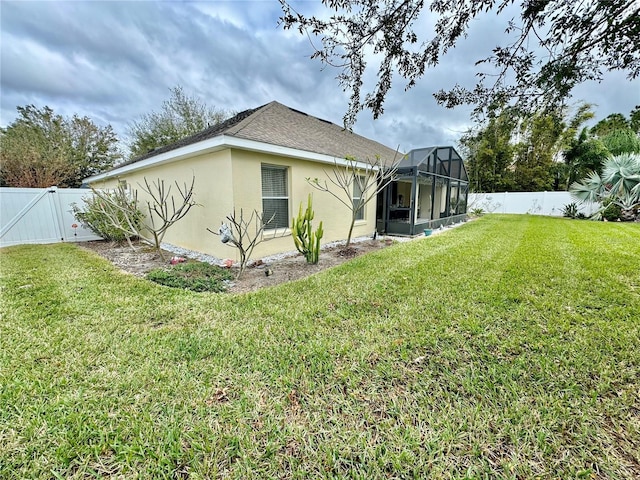 back of property with glass enclosure and a lawn