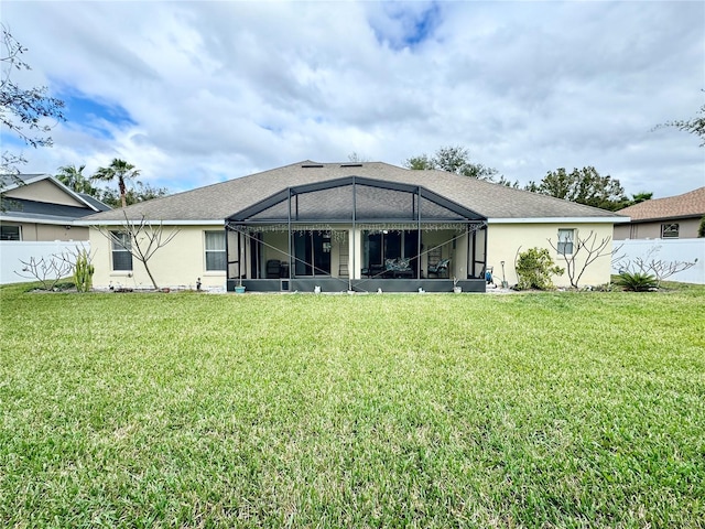 back of property featuring a lawn and glass enclosure