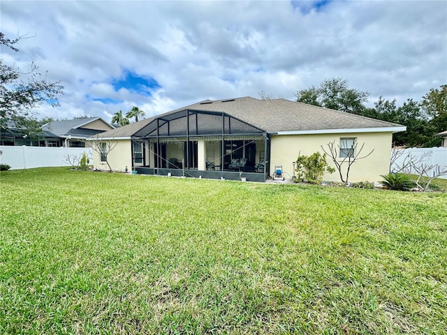 rear view of property featuring a lanai and a lawn