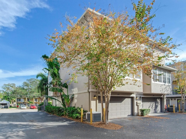 view of front of home with a garage and central air condition unit