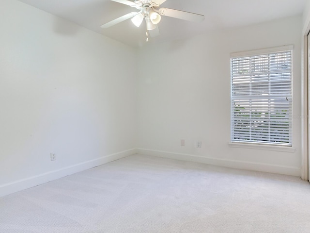 empty room featuring ceiling fan and light carpet