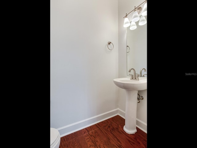 bathroom with wood-type flooring and toilet