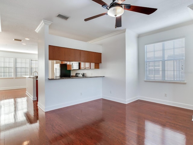 unfurnished living room featuring dark hardwood / wood-style flooring, ornamental molding, and a wealth of natural light