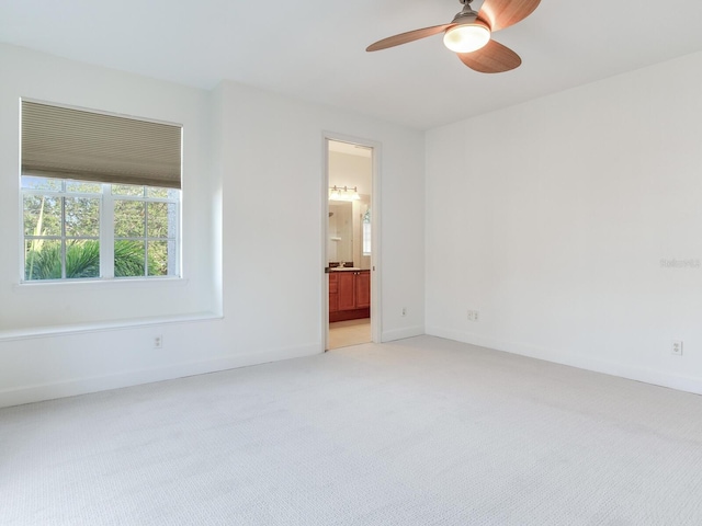 spare room with ceiling fan and light colored carpet