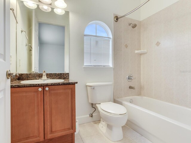 full bathroom with tile patterned floors, vanity, toilet, and tiled shower / bath combo