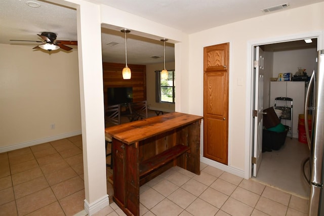 kitchen with ceiling fan, freestanding refrigerator, visible vents, and light tile patterned flooring