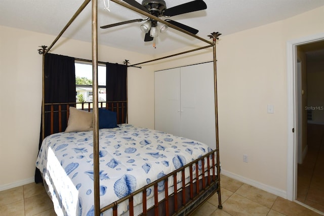 bedroom with a ceiling fan, a closet, baseboards, and light tile patterned floors