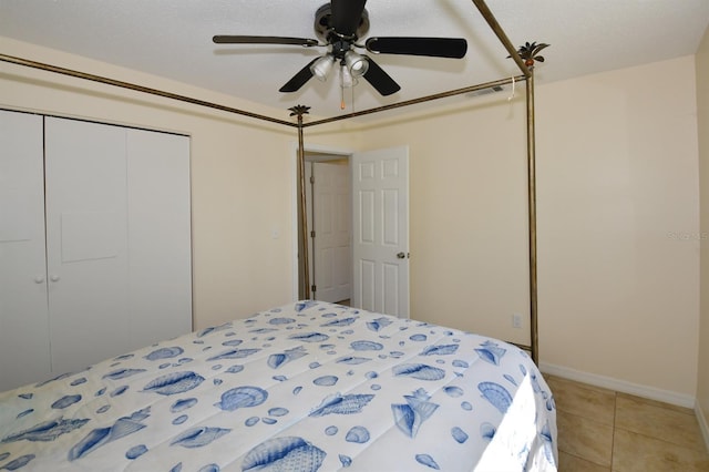 bedroom with a ceiling fan, a closet, baseboards, and light tile patterned floors