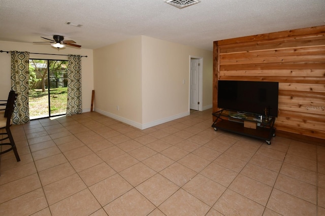 9567 85th St, Seminole, FL 33777 - unfurnished living room featuring a textured ceiling, a ceiling fan, light tile patterned floors, baseboards, and wood walls