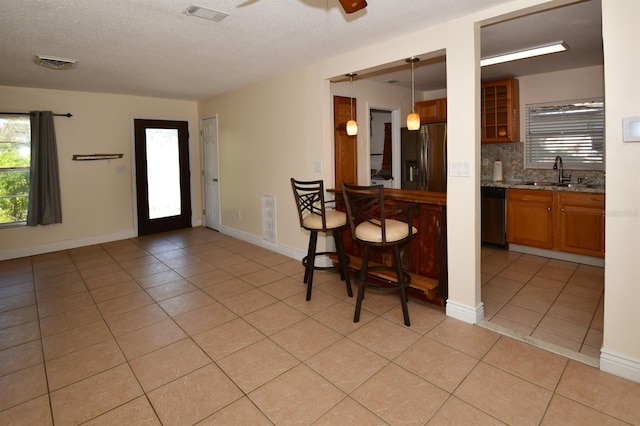 9567 85th St, Seminole, FL 33777 - kitchen with appliances with stainless steel finishes, a sink, light tile patterned floors, ceiling fan, and a textured ceiling