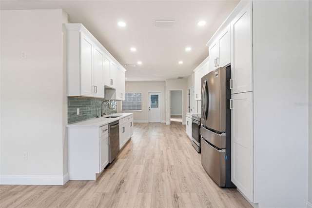 kitchen featuring white cabinets, light hardwood / wood-style floors, sink, and appliances with stainless steel finishes