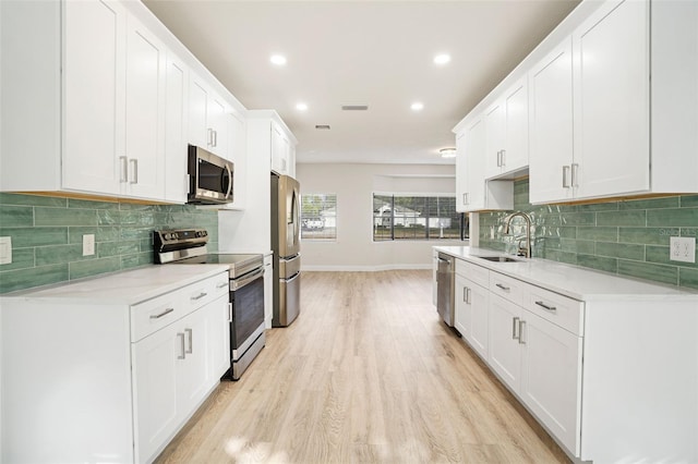 kitchen with sink, white cabinetry, and stainless steel appliances