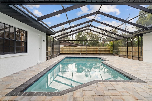 view of pool featuring glass enclosure and a patio