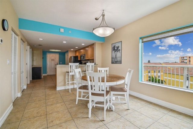 tiled dining space featuring a healthy amount of sunlight