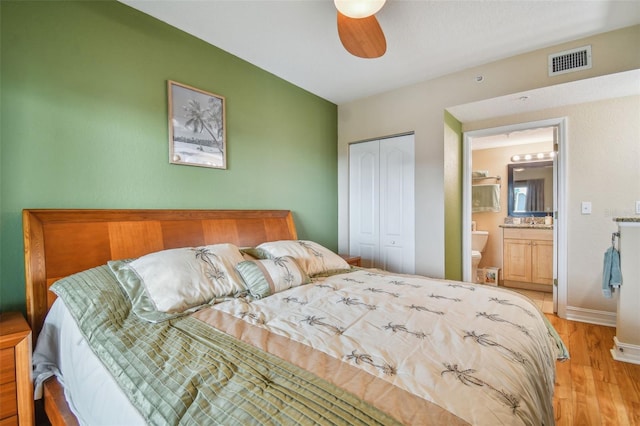 bedroom with ensuite bathroom, light hardwood / wood-style flooring, a closet, and ceiling fan