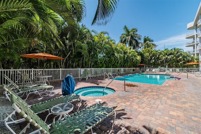 view of pool featuring a patio and a hot tub