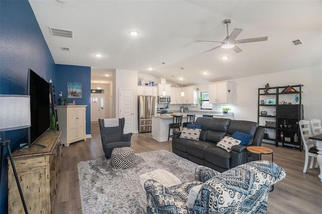 living room featuring ceiling fan, lofted ceiling, and hardwood / wood-style flooring