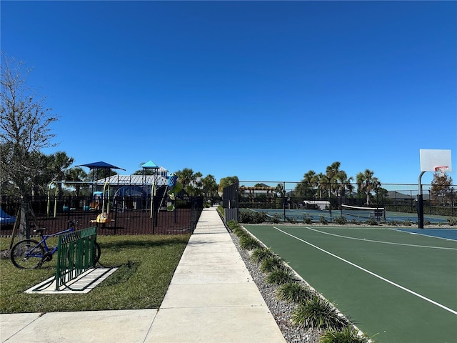 view of home's community featuring a lawn and basketball hoop