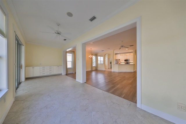 empty room featuring ceiling fan with notable chandelier, crown molding, and light hardwood / wood-style flooring