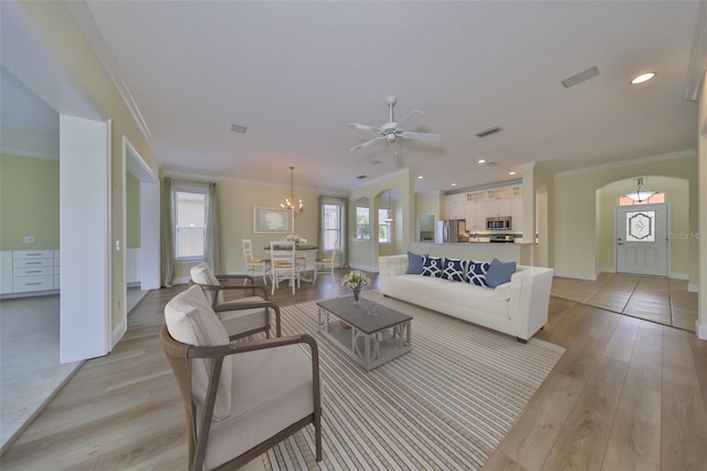 living room featuring light hardwood / wood-style flooring, ceiling fan with notable chandelier, and ornamental molding